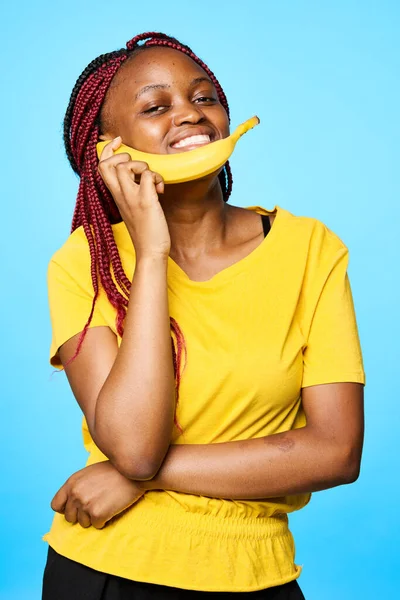 Young  woman   with banana  isolated on blue background