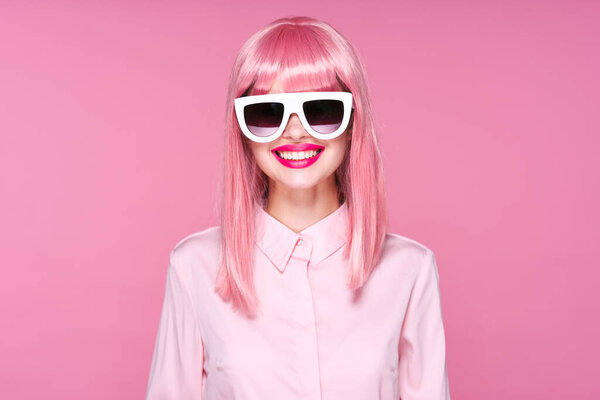 young beautiful woman in pink wig and sunglasses posing in studio 