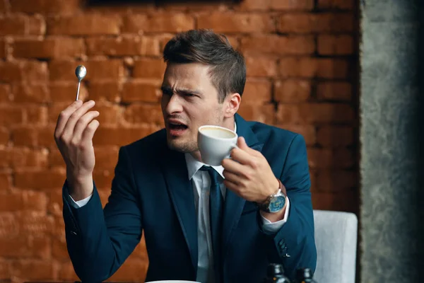 Young angry  businessman with coffee   in the office