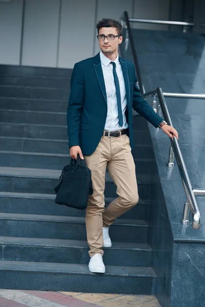 young businessman with bag on the street