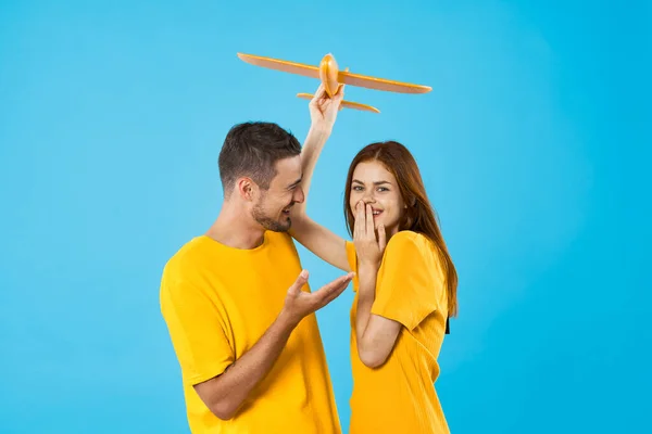 Jong Mooi Paar Spelen Met Geel Speelgoed Vliegtuig Blauwe Achtergrond — Stockfoto