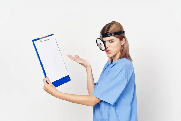 Young female angry doctor with document   in studio on white background