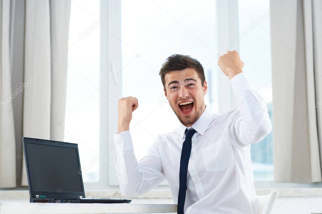 Young  handsome  happy businessman working  in the office 