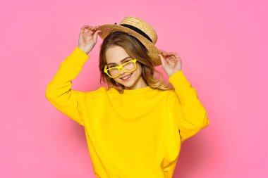 Stüdyoda pembe arka planda şapka takan güzel bir kadın.      