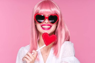 Pembe arka planda pembe peruklu genç kadın.