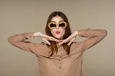 Stüdyoda poz veren güneş gözlüklü güzel bir kadın. 