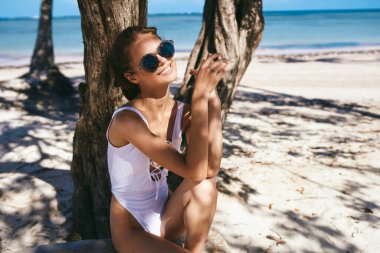 Genç ve güzel bir kadın sahilde dinleniyor.