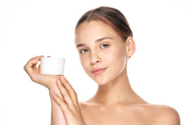 Genç ve güzel bir kadın krem tutuyor. 