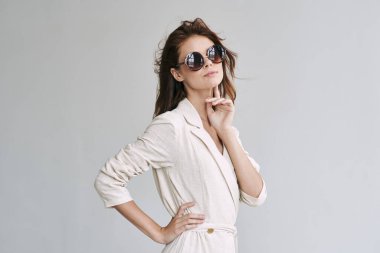 Stüdyoda poz veren güneş gözlüklü güzel bir kadın.  
