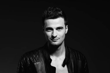 Stüdyoda poz veren yakışıklı bir genç. Siyah ve beyaz  