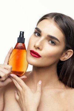 Stüdyoda güzellik ürünüyle güzel bir kadın var. 