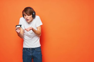 Kulaklıklı genç adam video oyunu oynuyor. 