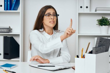 Ofiste oturan genç iş kadını dur işareti yapıyor.