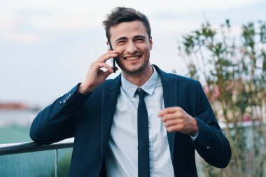 Akıllı telefonlu mutlu yakışıklı iş adamı