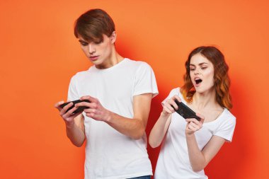 Stüdyoda akıllı telefonlarla oynayan genç çift.  