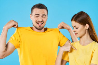 Stüdyoda izole edilmiş arka planda poz veren tişörtlü güzel bir çift.