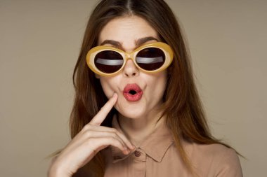 Stüdyoda poz veren güneş gözlüklü güzel bir kadın. 