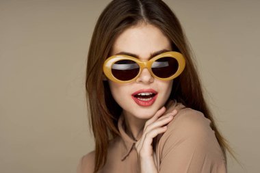 Stüdyoda poz veren güneş gözlüklü güzel bir kadın. 