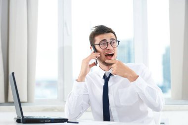 İş konsepti. Akıllı telefondan konuşan genç bir iş adamı. 