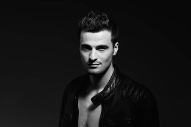 Stüdyoda poz veren yakışıklı bir genç. Siyah ve beyaz  