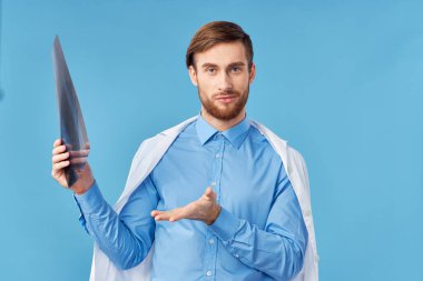 Stüdyoda, elinde röntgen olan bir erkek doktor. 