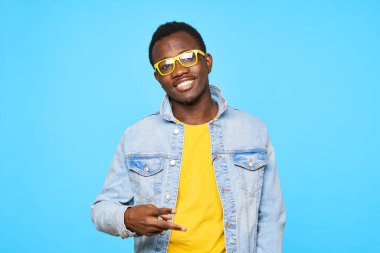 Genç Afrikalı bir adam mavi arka planda izole edilmiş.