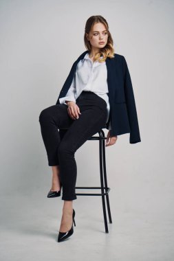 Taburede poz veren genç ve güzel iş kadınının portresi. 