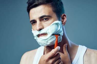 Genç ve yakışıklı bir adamın traş olurken çekilmiş bir fotoğrafı. 