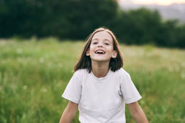 Genç tatlı kız papatya tarlasında eğleniyor.