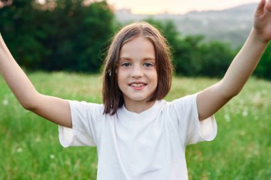 Genç tatlı kız çayırda eğleniyor.