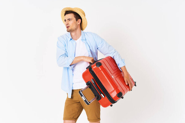 Studio shot of young man tourist holding his suitcase