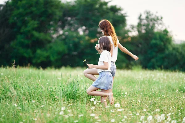 若いです母と彼女の娘持っています楽しいです上のカモミールフィールド — ストック写真