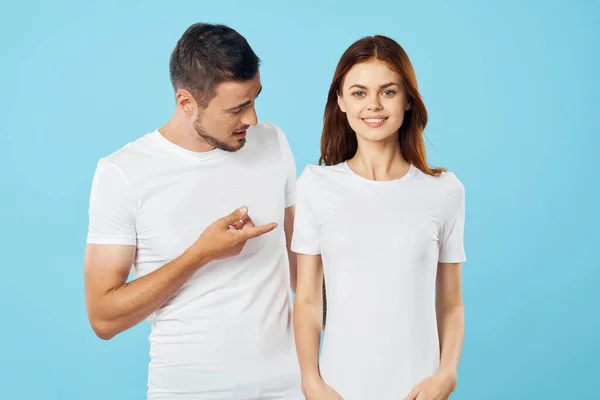 young beautiful couple in  t-shirts posing in studio on isolated background