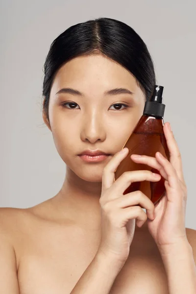 Young asian woman with hair spray in studio. Beauty, fashion photography