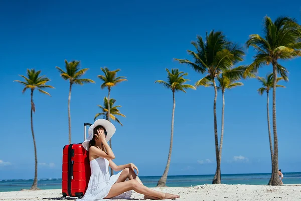若いです女性とともに赤いスーツケースオンビーチ — ストック写真