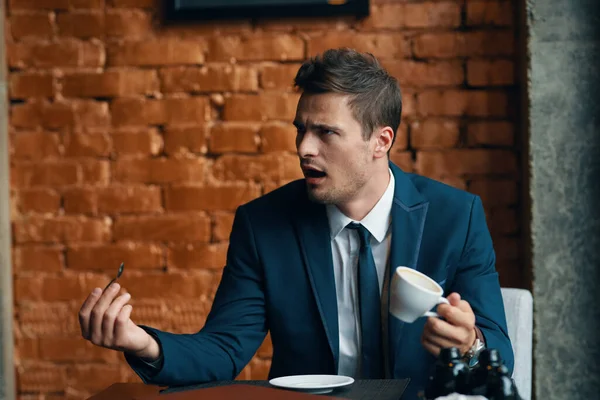 Young  angry businessman   with coffee cup