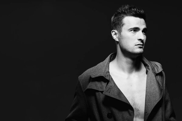 Studio shot of young handsome man posing in studio. Black and white  