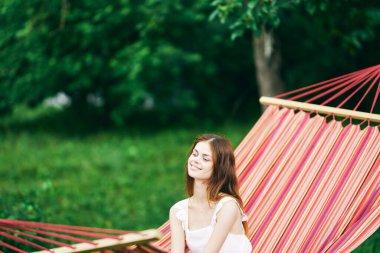 Genç ve güzel bir kadın hamakta dinleniyor.