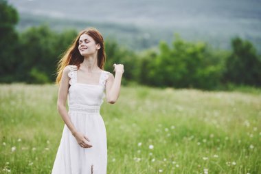 Kırsalda poz veren genç bir kadın. 