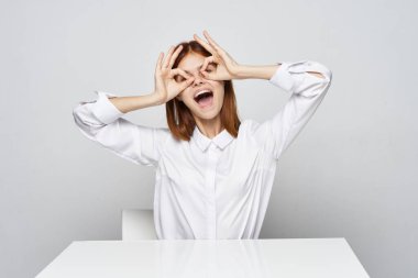  Ofiste oturan iş kadını bardakları gösteriyor.