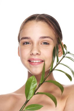 Stüdyoda yaprağıyla poz veren genç ve güzel bir kadın.