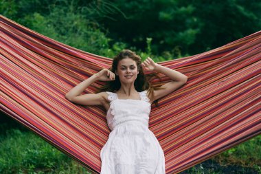 Genç ve güzel bir kadın hamakta dinleniyor. 