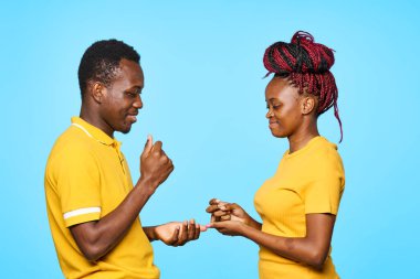 Stüdyoda mavi arka planda poz veren genç ve güzel bir çift