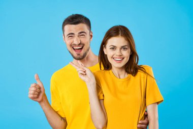Genç yakışıklı adam ve kadın stüdyoyu mavi arka planda gösteriyorlar. 