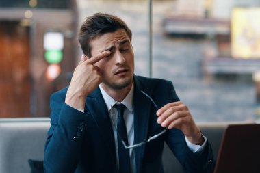 Kafede gözlüklü yakışıklı bir iş adamı oturuyor. 