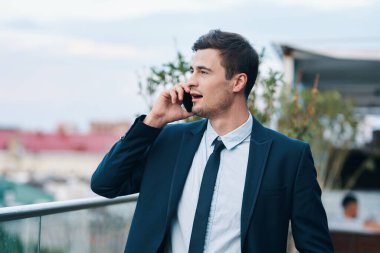 Sokakta akıllı telefonu olan yakışıklı bir iş adamı.