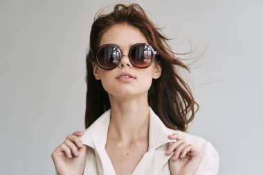 Stüdyoda poz veren güneş gözlüklü güzel bir kadın.  