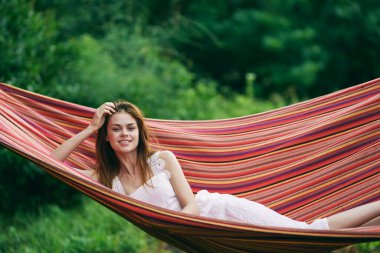 Genç ve güzel bir kadın hamakta dinleniyor. 