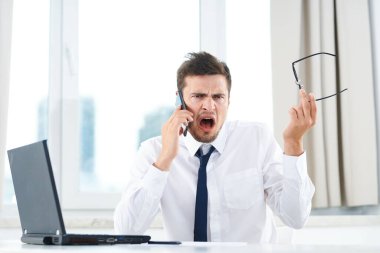 İş konsepti. Yong ofisteki akıllı telefondan konuşan işadamı hayal kırıklığına uğradı. 