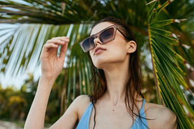 Genç ve güzel bir kadın sahilde dinleniyor.